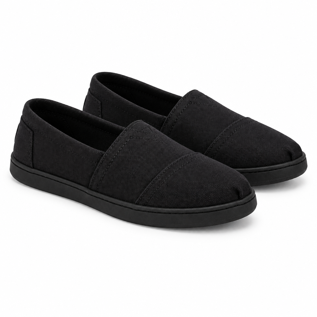 Pair of all-black canvas slip-on shoes at 45 degree angle